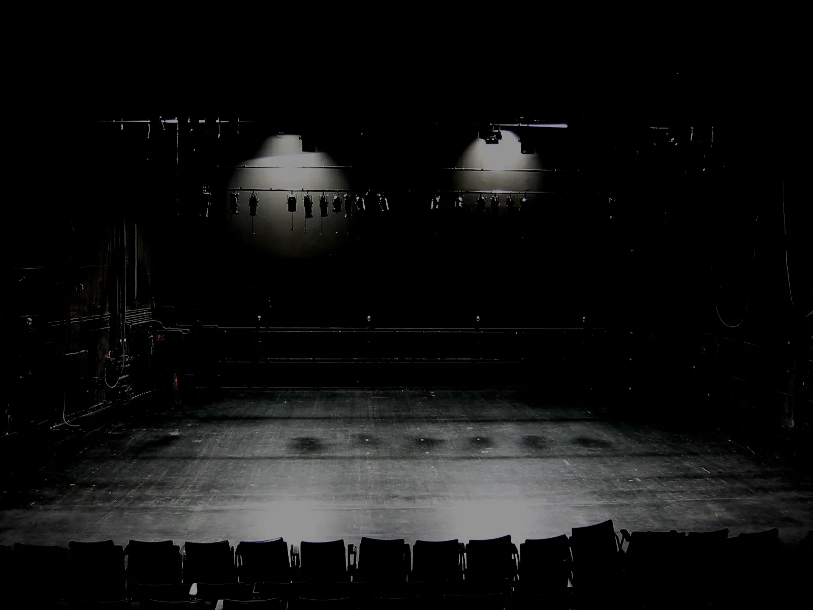 Empty theatre stage lit in low, dark light